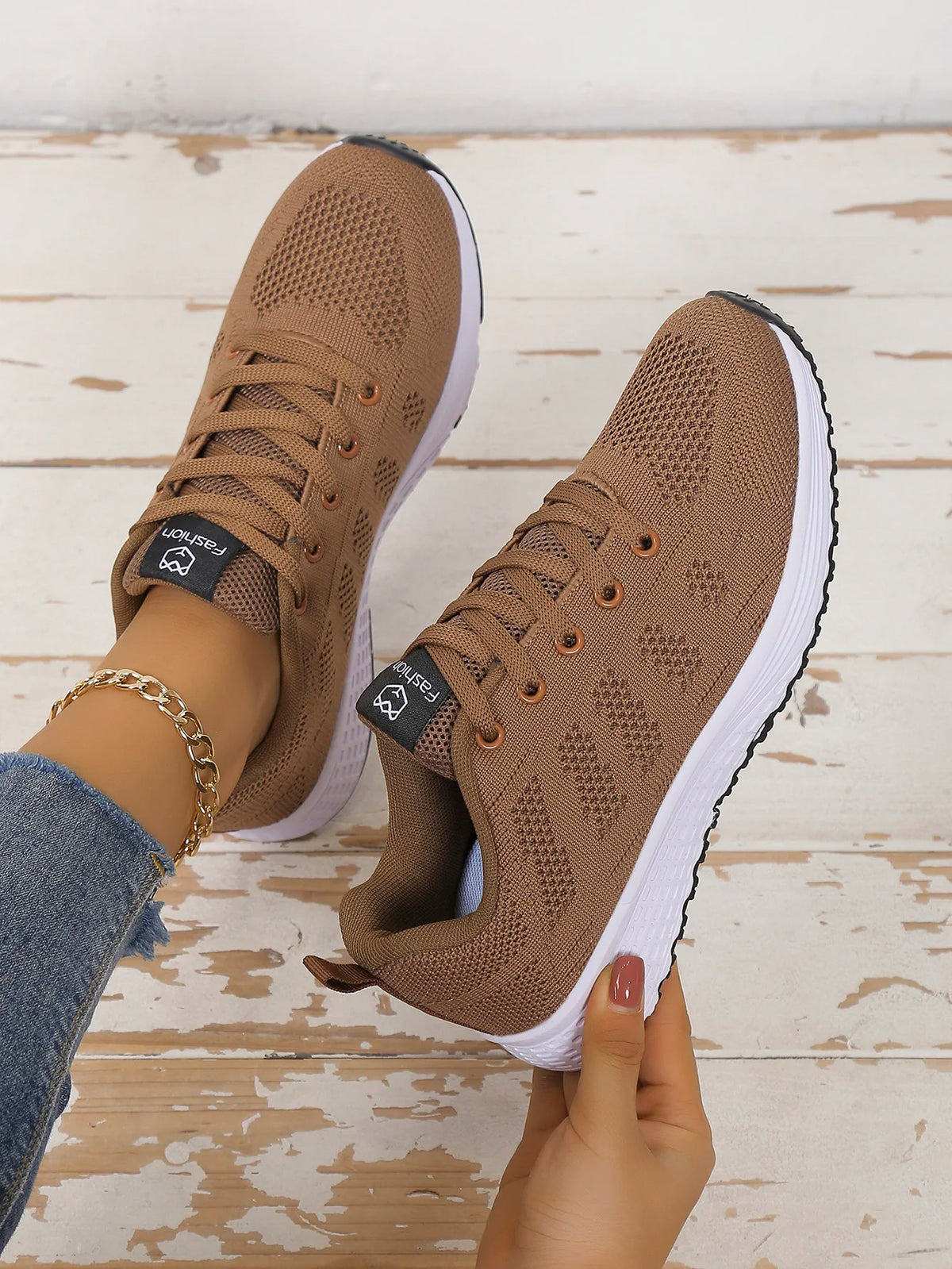 Women’s casual sports shoes with solid-colored fabric and front lacing, suitable for outdoor leisure wear.